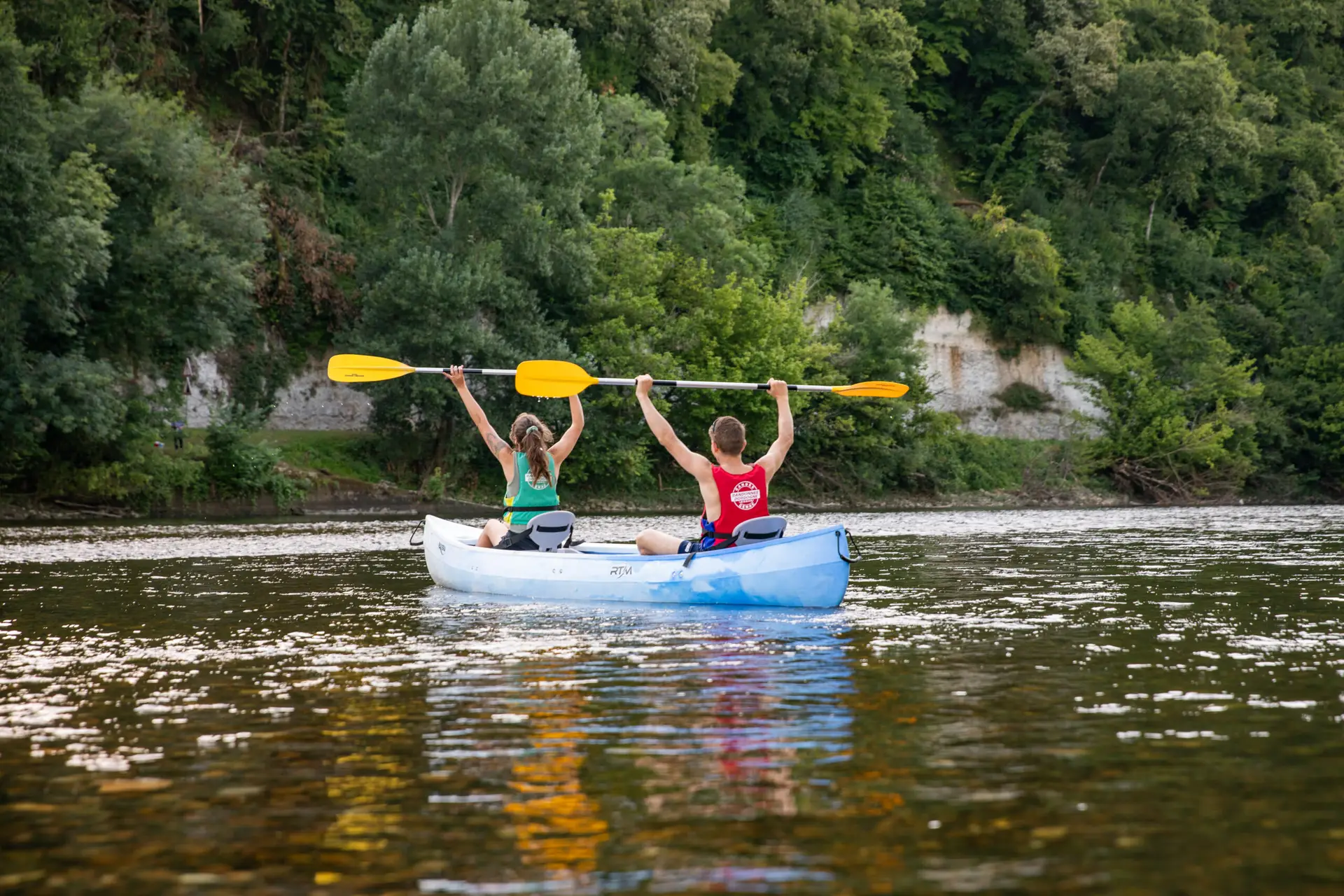 Personnes en canoë qui lèvent les mains